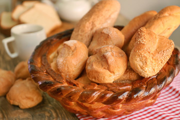 Braided bread basket with delicious loaves on table
