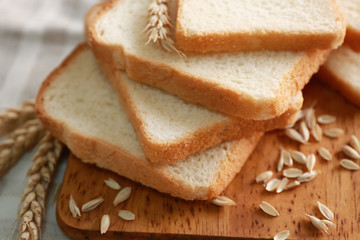 Fototapeta na wymiar Delicious sliced bread on wooden cutting board