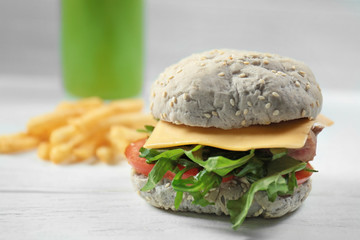 Delicious sandwich with fish on wooden table