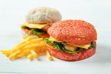 Tasty sandwich with shrimps and French fries on wooden table