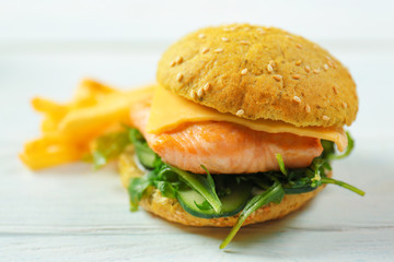 Delicious sandwich with fish on wooden table