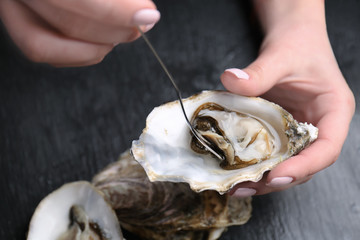 Woman eating delicious oyster, closeup