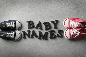 Text BABY NAMES and shoes on gray background