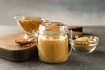 Composition with delicious mustard sauce in jar on table