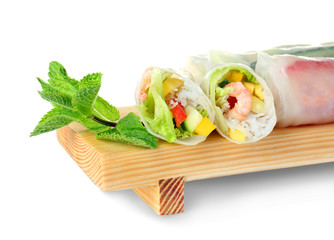 Spring rolls on wooden board against white background