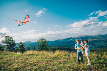 family running through field letting kite fly