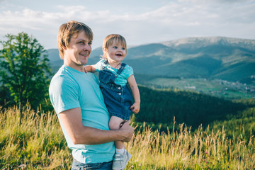 father and little daughter on his hands on the top of the mountains