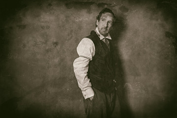 Classic wet plate photo of vintage 1900 western man leaning against wall.
