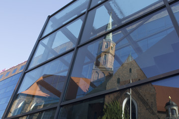 Spiegelung einer Kirche in moderner Glasfassade - 167357766