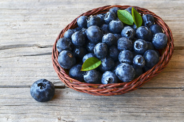 Freshly picked blueberries in a basket on old wooden background.Fresh blueberries with green leaves on rustic table. Blueberry.
Bilberry.Healthy eating,diet and nutrition concept.