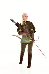 full length portrait of a blonde girl wearing green and brown medieval costume, holding a bow and...
