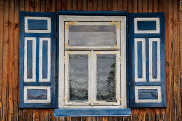 Obraz premium Decorative blue white painted shutters of the wooden house in the countryside region of eastern Poland