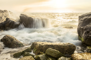 A gentle sea at dawn. Splashes and waves on a long exposure, very slow focus.
