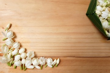Floral background with white jasmine flowers on a wooden plank