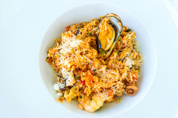 Tasty risotto with Shrimp, fresh herbs vegetables on a white plate