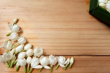Obraz na płótnie Canvas Floral background with white jasmine flowers on a wooden plank