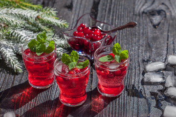 Cranberry drinks with mint on dark rustic wooden background, selective focus