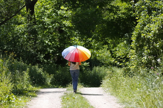 A girl in the nature with an umbrella in the forest