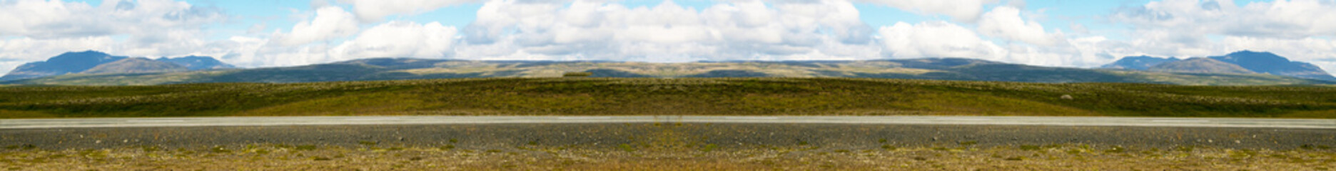 Iceland landscape with fields, mountains, sky, clouds, road and hills. Copy space.