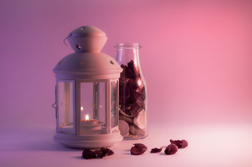 Romantyczny koncept, świecznik i płatki róży w butelce © Ma