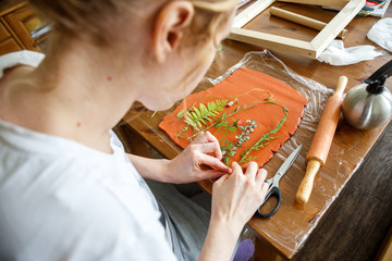 Woman making botanical plaster artwork in her home studio.