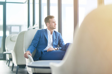 Positive handsome businessman sitting in the restaurant