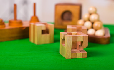 Wooden block brain teaser puzzle on green table in a blurred background