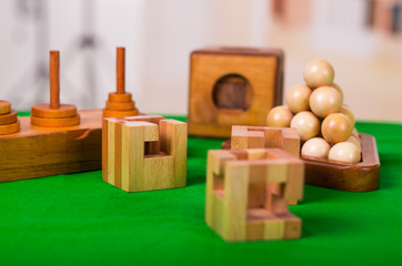 Wooden block brain teaser puzzle on green table in a blurred background