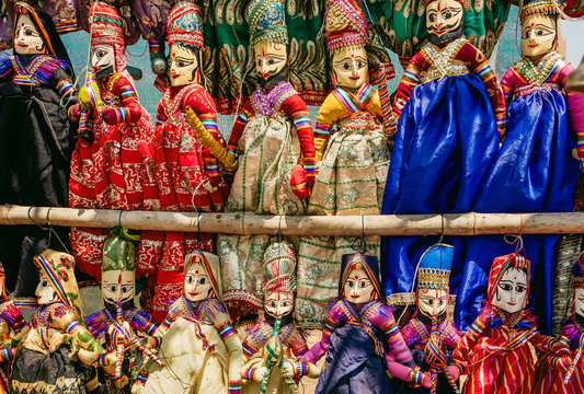 Colorful handcrafted dolls in traditional costumes of India. Marketplace with old style indian toys for children