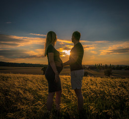 Couple in love, waiting on newborn in wheat field