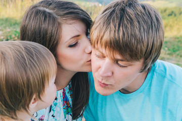 mother kiss father in cheek in front of daughter