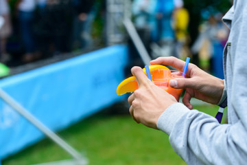 woman holding a glass with blue cold summer cocktail outdoors, selective focus. Concept of vacation, summer holiday and relaxing