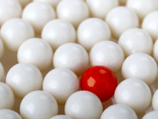 stand out red ball surrounded by white balls