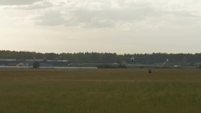 Small airplane lands on the grass field - slowmotion 60 fps