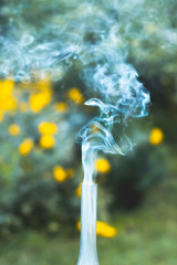 A smoking old kerosene lamp on a green grass.