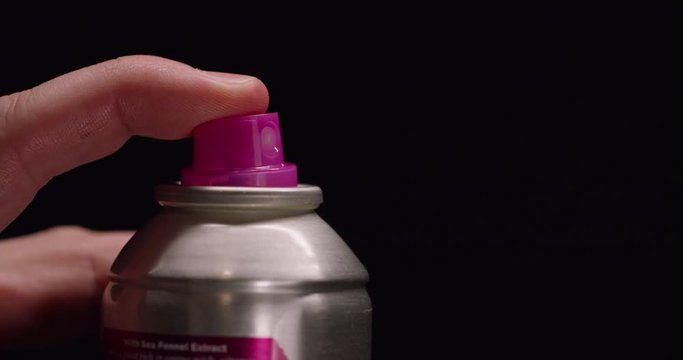 Slow motion, close up of person spraying hairspray from can