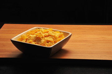 Tasty cornflakes on black background