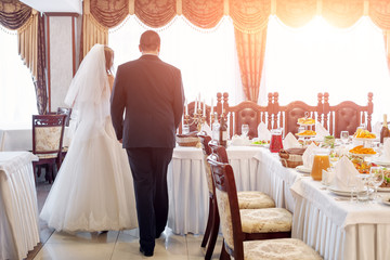 Bride and groom in restaurant. Wedding table at a wedding feast, dinner and party.