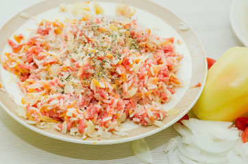 Raw minced meat with rice and spices, fresh vegetables. Ingredients for home cooking.