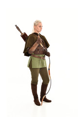 full length portrait of a blonde girl wearing green and brown medieval costume, holding a bow and...