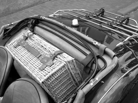Picknickkoffer aus Korbgeflecht auf dem Notsitz eines englischen Roadster der F&uuml;nfzigerjahre beim Oldtimertreffen Golden Oldies in Wettenberg Krofdorf-Gleiberg bei Gie&szlig;en in Hessen in Schwarzwei&szlig;