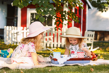 Two little girls sitting on green grass