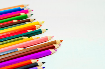 Fototapeta premium Colored pencils on white background. Close-up, copy-space for text.