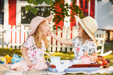 Two little girls sitting on green grass