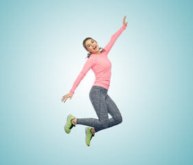 Obraz premium happy smiling sporty young woman jumping in air