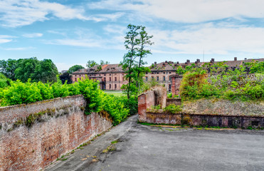 Fototapeta na wymiar View of abandoned and ruined buildings of the ancient damaged Cittadella of Alessandria in Italy. HDR effect.