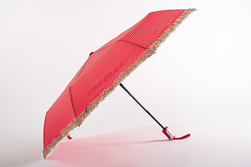Opened red dot umbrella isolated on white background
