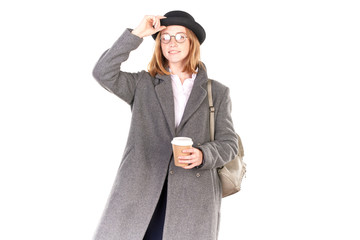 Portrait of teenage hispter girl wearing gray overcoat and black hat isolated on white