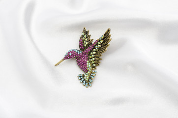 Brooch hummingbird with color diamonds on silk fabric