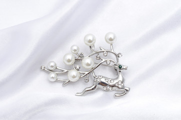 Silver brooch deer with pearls on silk fabric